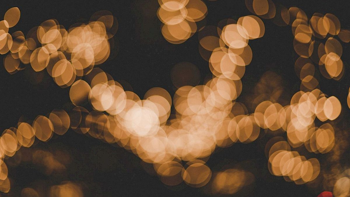 The image shows a bokeh effect created by blurred, out-of-focus lights in a warm amber color scattered across a dark background.